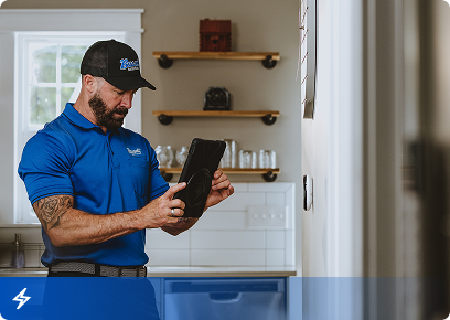 Bassett Services electrician reviewing a tablet in a home kitchen
