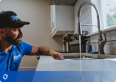 Bassett Services plumber checking a kitchen sink faucet